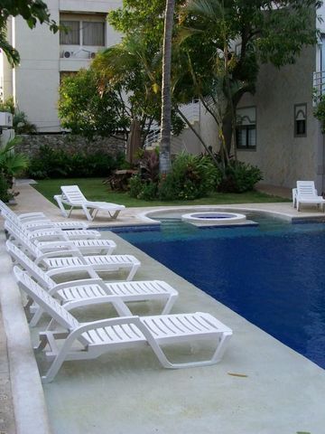 Großer Außenpool mit weißen Sonnenliegen und Whirlpool