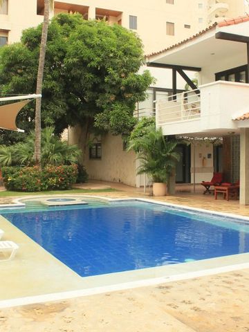 Großer Poolbereich mit Liegestühlen und Villa im Hintergrund