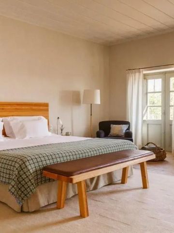 Gemütliches Zimmer mit Doppelbett, Holzbank und großen Fenster