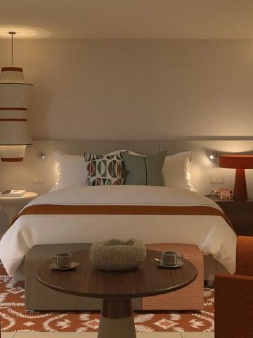 Hotelzimmer mit Doppelbett und warmen Farbtönen