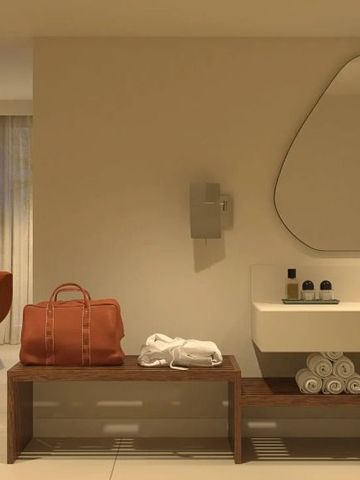 Helle Sitzecke in einem Hotelzimmer mit Designerstuhl und Spiegel