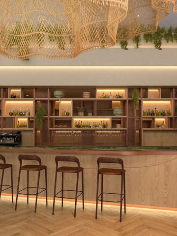 Elegante Hotelbar mit stilvoller Beleuchtung und hohen Barhockern