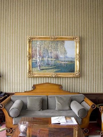 Eleganter Salon mit antikem Sofa und Gemälde an der Wand im Schlosshotel Berlin