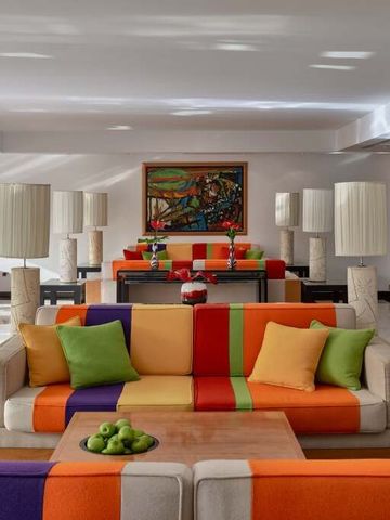 Elegante Lounge mit bunter Möblierung und modernen Kunstwerken.