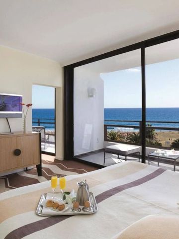 Geräumiges Zimmer mit Panoramafenstern und Meerblick.