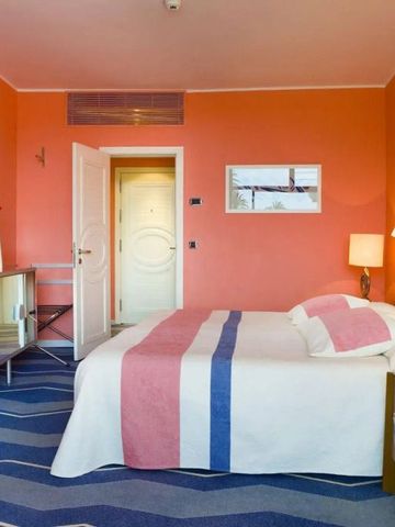 Helles Hotelzimmer mit orangefarbenen Wänden und modernen Möbeln