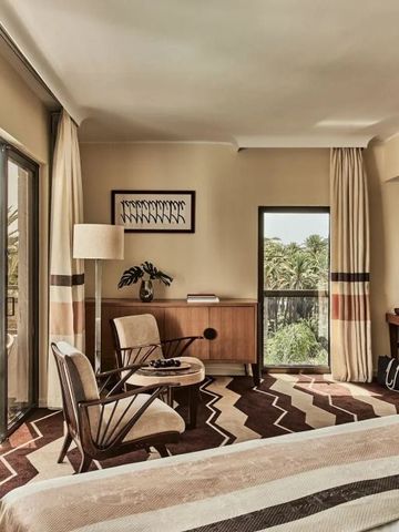 Helles Schlafzimmer mit Palmenblick und eleganter Einrichtung