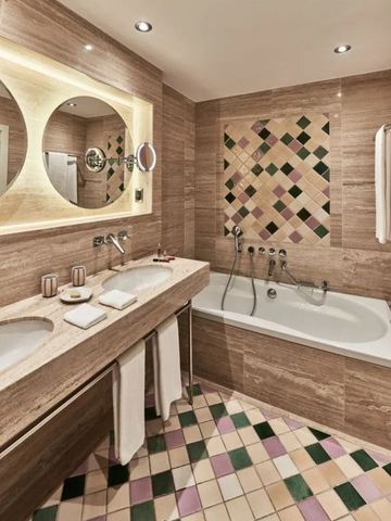 Luxuriöses Bad mit Marmorfliesen und eleganter Badewanne