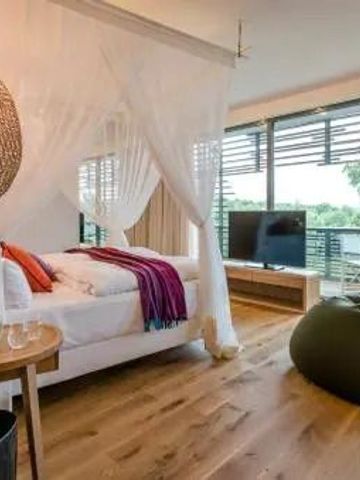 Luxuszimmer mit Baldachinbett und Holzfußboden im Hotel Seezeitlodge