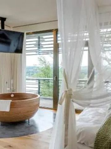 Zimmer mit freistehender Badewanne und großem Fenster im Hotel Seezeitlodge