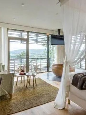 Geräumiges Zimmer mit Sitzbereich und großem Fenster im Hotel Seezeitlodge