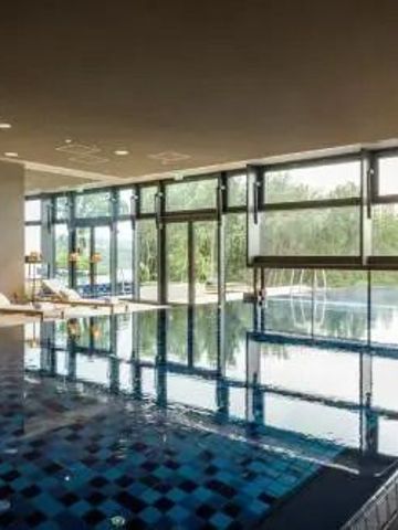 Innenpool mit Panoramafenstern und Blick auf die Natur