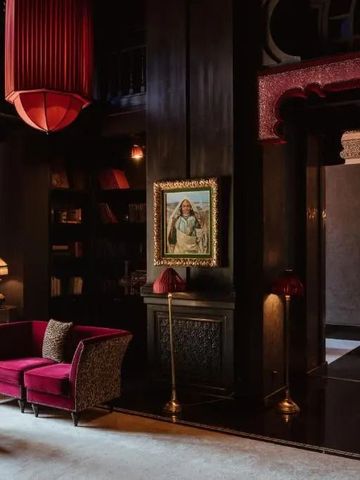 Luxuriöse Hotellobby mit roten Sofas und gedämpftem Licht