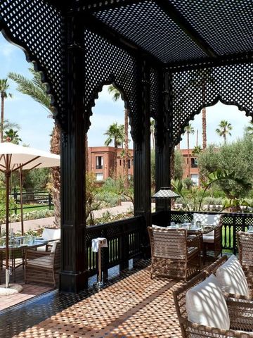 Terrasse mit geschnitzten Holzelementen und Blick auf den Garten