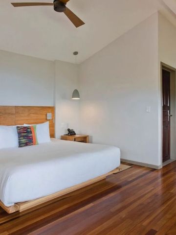 Modernes Hotelzimmer mit hellem Interieur und Deckenventilator