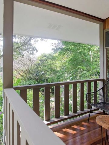 Holzveranda mit Blick auf üppigen tropischen Garten