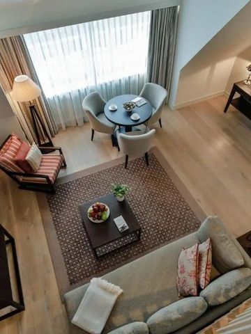 Blick von oben auf einen eleganten Wohnbereich mit Sofa und Sitzbereich in einer Suite