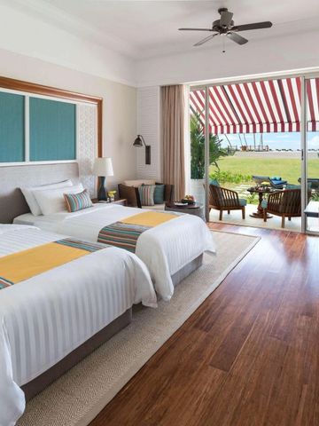 Zimmer mit zwei Betten und Blick auf den Garten und das Meer