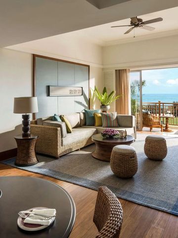 Wohnbereich mit Sofa und Balkon in tropischer Umgebung