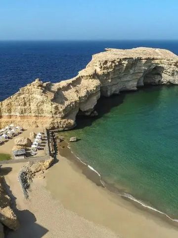 Strandabschnitt mit weißem Sand und Felsen am Shangri-La Al Husn Hotel