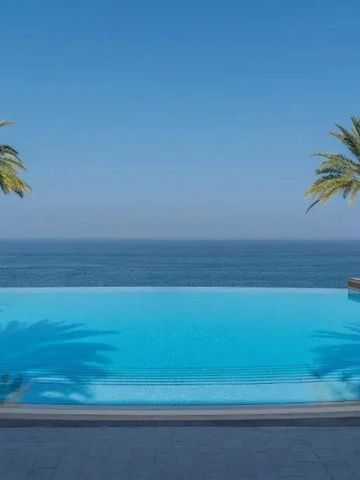 Infinity Pool mit Meerblick umgeben von Palmen im Shangri-La Al Husn Muscat
