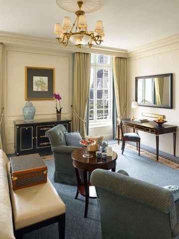 Hotelzimmer mit gemütlicher Sitzecke und großen Fenstern