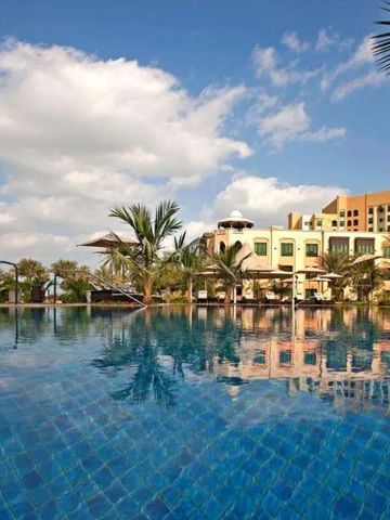 Infinity-Pool mit Blick auf Palmen und Hotelgebäude bei sonnigem Wetter