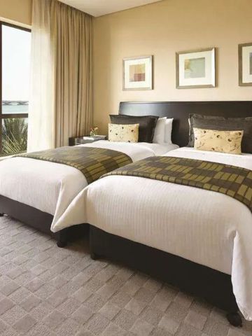 Zweibettzimmer mit moderner Einrichtung und großem Fenster