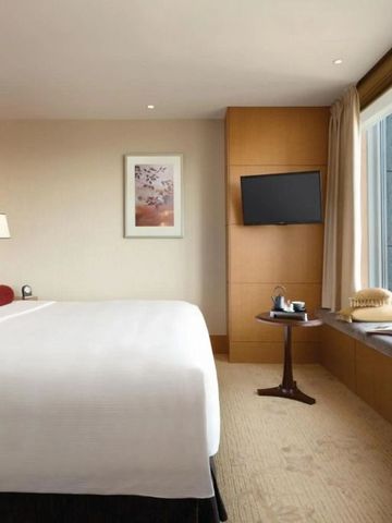 Helles Hotelzimmer mit großem Fenster und Ausblick über die Stadt Tokyo