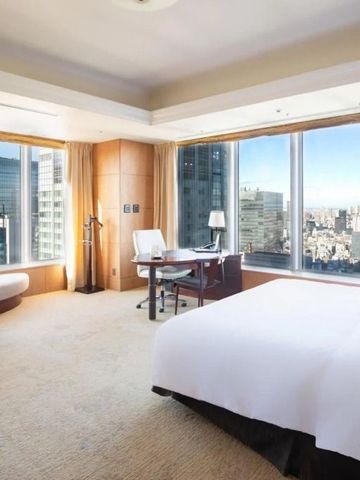 Geräumiges Zimmer mit großen Fenstern und Blick auf die Stadt