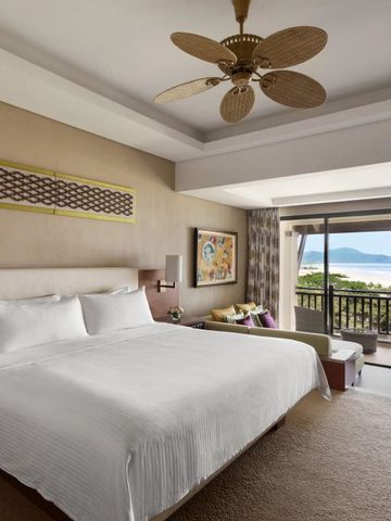 Luxuriöses Zimmer mit Doppelbett und Balkonblick auf das Meer.