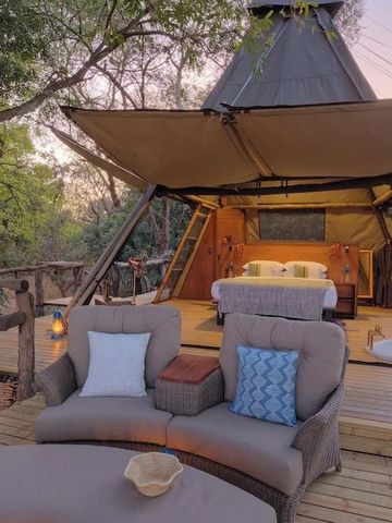 Luxuriöses Zelt mit Terrasse und gemütlichen Sitzgelegenheiten in der Natur