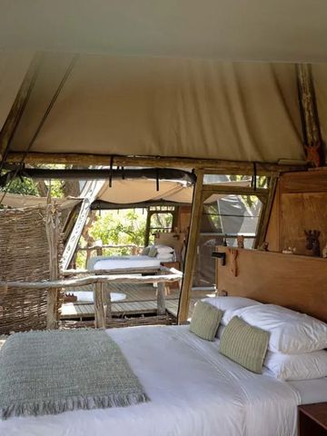 Zimmer mit Holzwänden und großen Fenstern, durch die viel Licht einfällt.