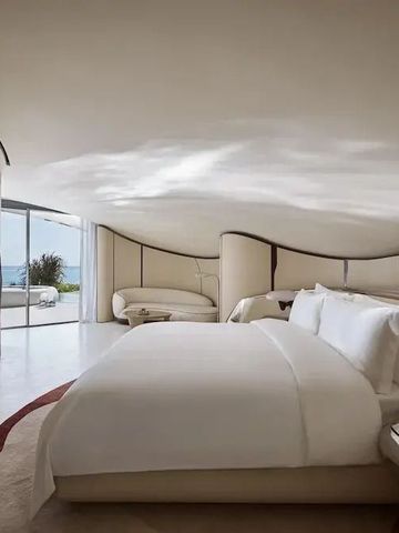 Großzügiges Schlafzimmer mit Meerblick und stilvollen Möbeln.