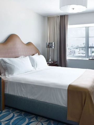 Helles Hotelzimmer mit stilvollem Doppelbett und modernen Dekorelementen