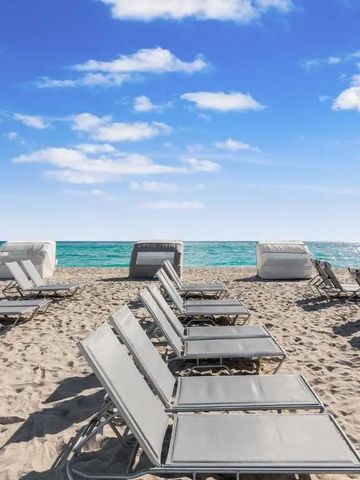 Strand mit Reihen von eleganten Liegestühlen und Blick auf das blaue Meer