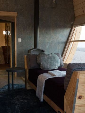 Innenansicht eines Zimmers mit großem Fenster und Blick auf die Wüste