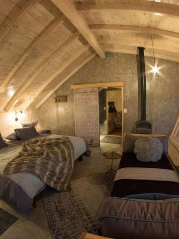 Gemütliches Zimmer mit Holzdach und zwei Betten im Shipwreck Lodge Hotel.