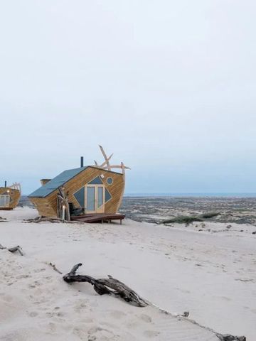 Einzigartige Hütten im Schiffsdesign auf einer Sanddüne in Namibia.