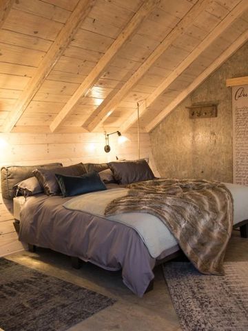 Gemütliches Schlafzimmer unter einem Dach mit Holzverkleidung