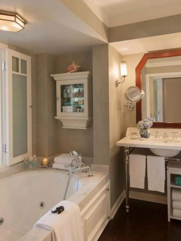 Helles Badezimmer mit Badewanne und Spiegel im Hotel Shutters on the Beach.