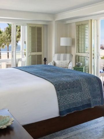 Helles Schlafzimmer mit Meerblick und Balkon im Hotel Shutters on the Beach.