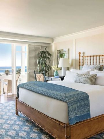 Gemütliches Schlafzimmer mit Balkon und Meerblick im Hotel Shutters on the Beach.