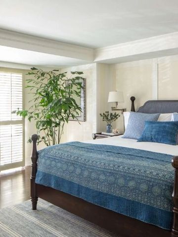 Helles Schlafzimmer mit blauer Überdecke und großen Fenstern im Hotel Shutters on the Beach.