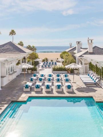 Luxuriöser Hotelpool mit Liegen und Meerblick bei sonnigem Wetter