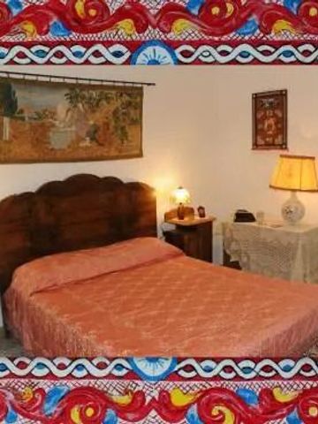 Schlafzimmer mit kunstvollen Textilien und Beleuchtung