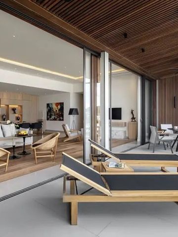 Helles Wohnzimmer mit offener Terrasse und Liegestühlen