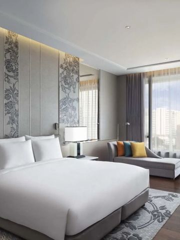 Helles Hotelzimmer mit King-Size-Bett und moderner Einrichtung