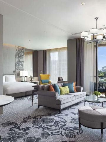 Geräumige Suite mit modernem Design, helle Fensterfront, gemütliche Sitzbereich.