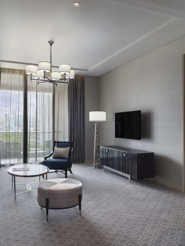 Geschmackvoll eingerichtetes Wohnzimmer in der Suite mit großem Fenster, luxuriöse Ausstattung.